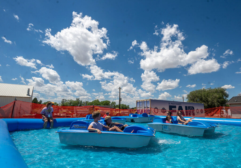 This image has an empty alt attribute; its file name is 071326-news-county-fair-13-1024x716.jpg
During the hot, dry week at the El Paso County Fair, attendees can cool off at the Pirates Rebellion, an action-packed inflatable adventure area, with inflatables with wet water slides and this small “pond” with paddle boats. Sunday, July 12, 2026. (The Gazette, Jerilee Bennett)