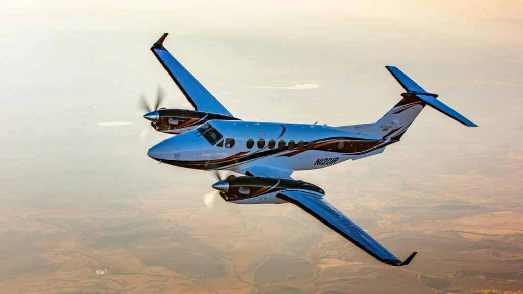 Aircraft in flight above a sunlit landscape.