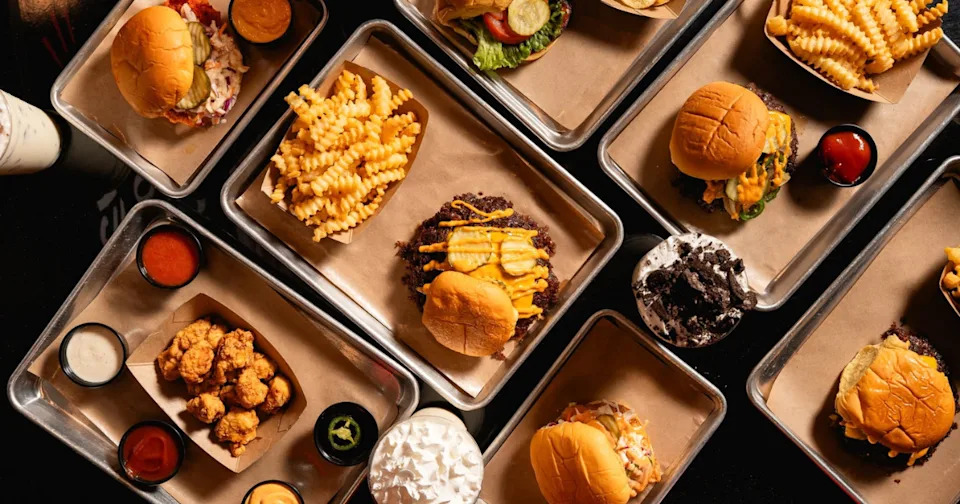 View from above of several trays of food at ZOJAH Burger in San Antonio, showcasing the restaurant's many offerings