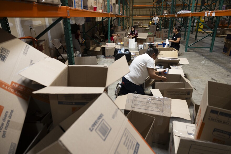 Volunteers work to sort clothing, food and other donations at a warehouse in North Austin, Texas, on July 1, 2026. The donations and work is in response to the recent earthquakes in Venezuela, where many citizens are in need of several necessities. Lorianne Willett/KUT News