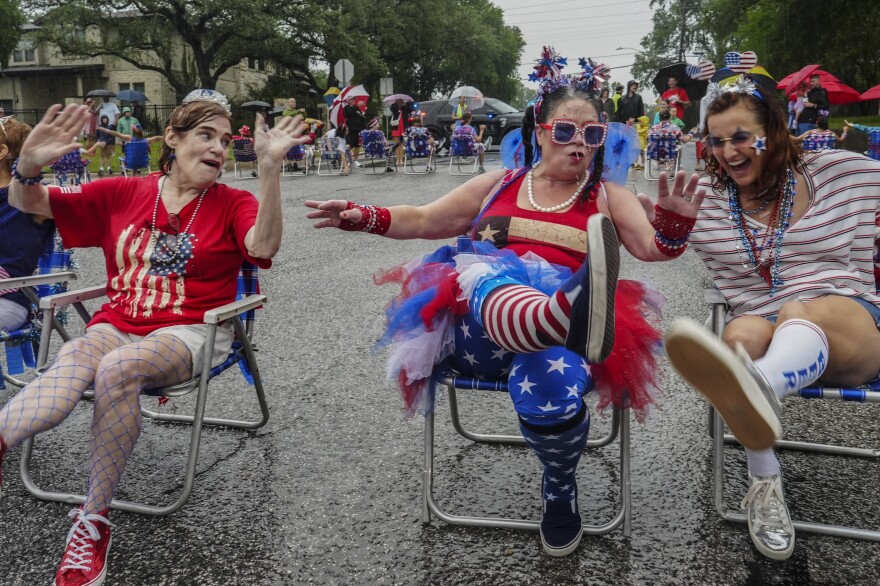 Ann Denkler, left, and Lyn Hendricks, center, marched with the Northwest Hills Lawn Chair Brigade during a downpour in 2023.