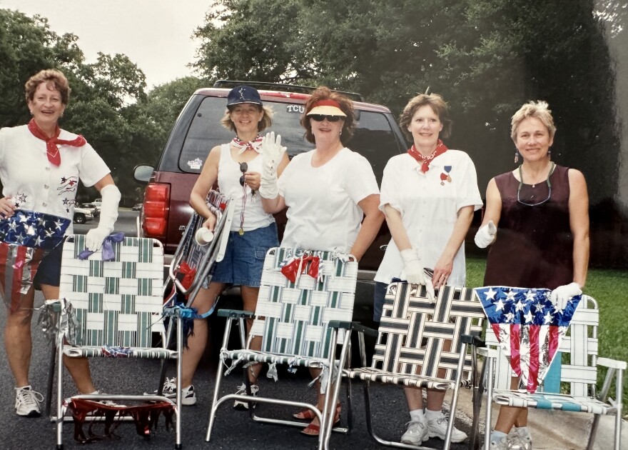 A row of five patriotically dressed women pose with lawn chairs.