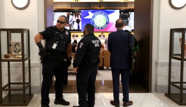 Former Dallas County Fire Marshal assistant chief Zack Masri, center, stands at a Dallas County Commissioners Court meeting April 1, 2025.