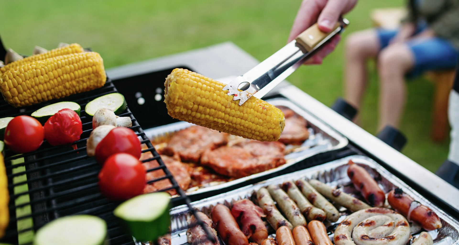 Close-up picture of mixed sausages and meat and vegetables grilling on barbecue. 