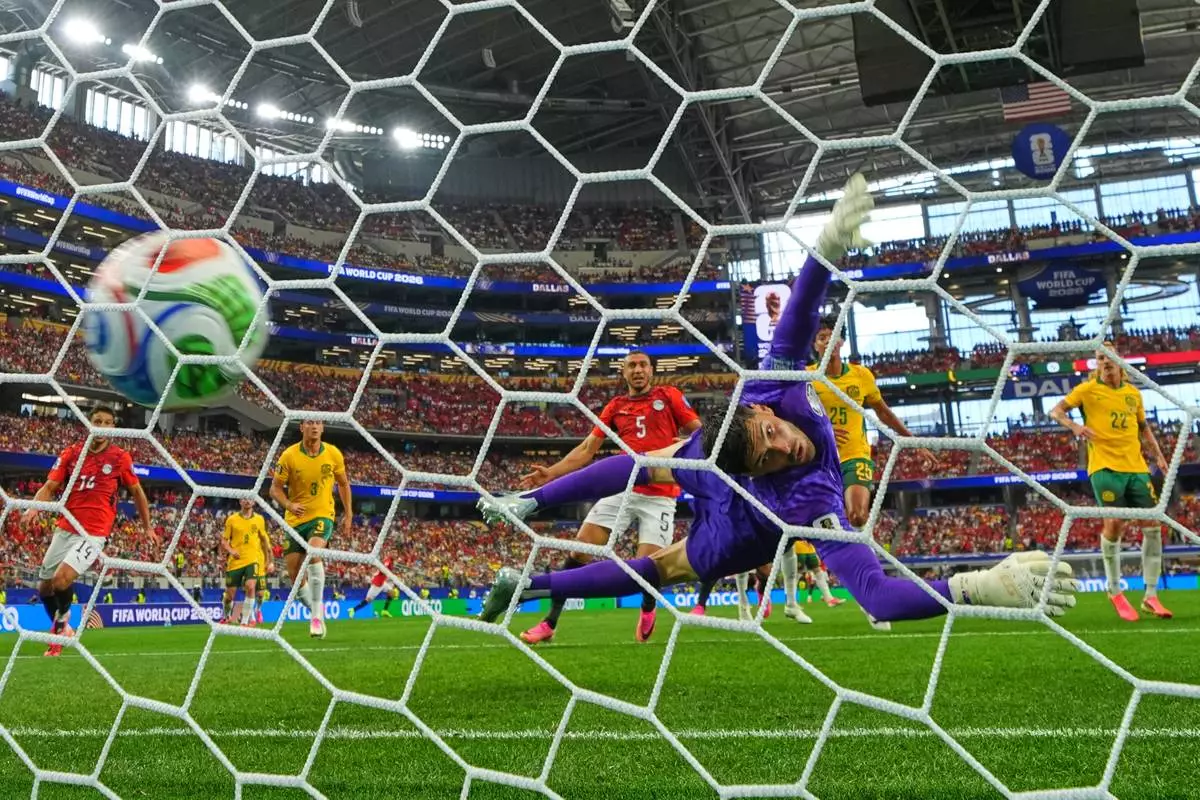 Egypt's Emam Ashour (8) scores the opening goal past Australia goalkeeper Patrick Beach (18) during the World Cup round of 32 soccer match between Australia and Egypt in Arlington, Texas, near Dallas, Friday, July 3, 2026. (AP Photo/Julio Cortez)