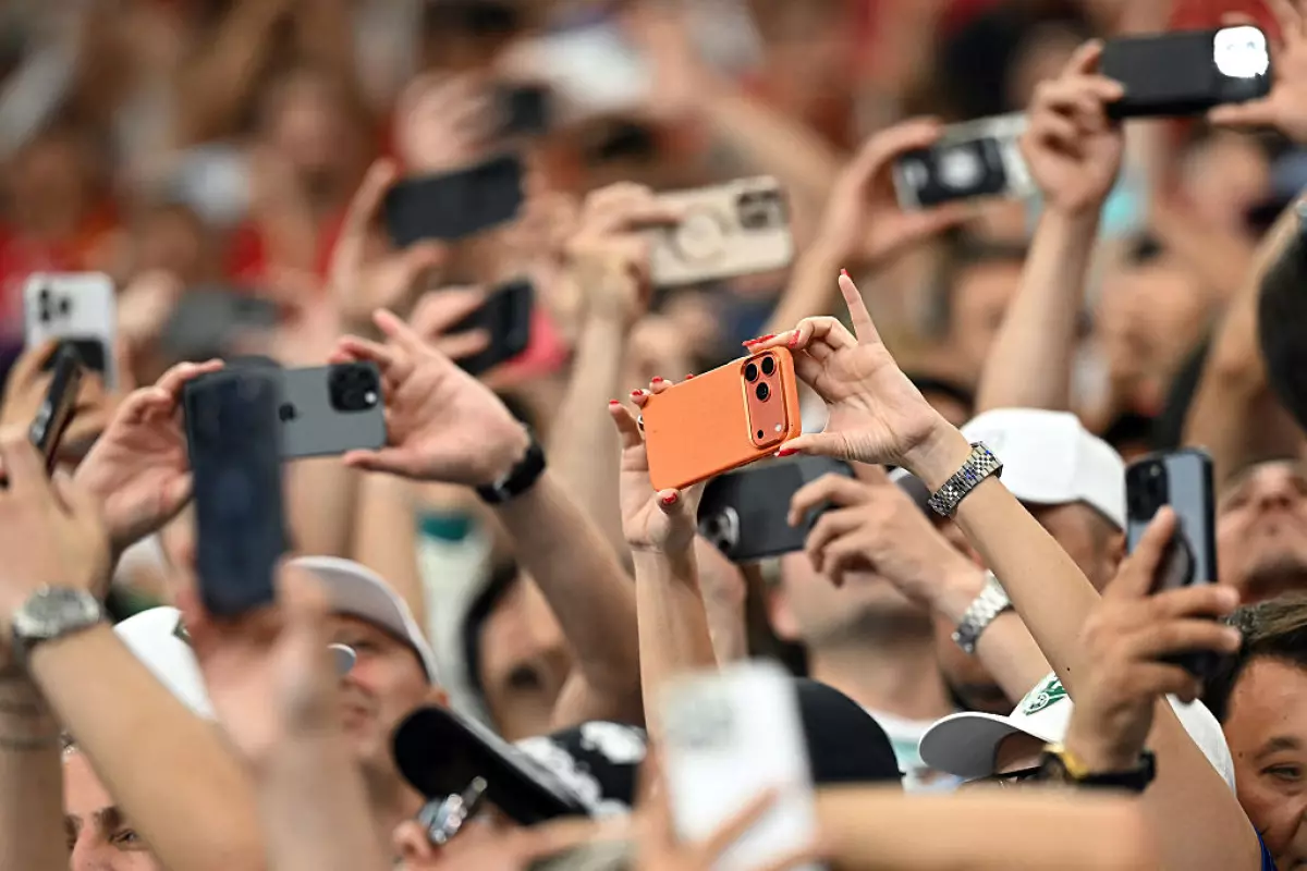 Spectators take photos with their smartphones during a World Cup match at the Houston Stadium in Houston on June 23. The Supreme Court is allowing Texas to enforce a law that limits minors' access to app stores on mobile devices while lawsuits continue in the lower courts.