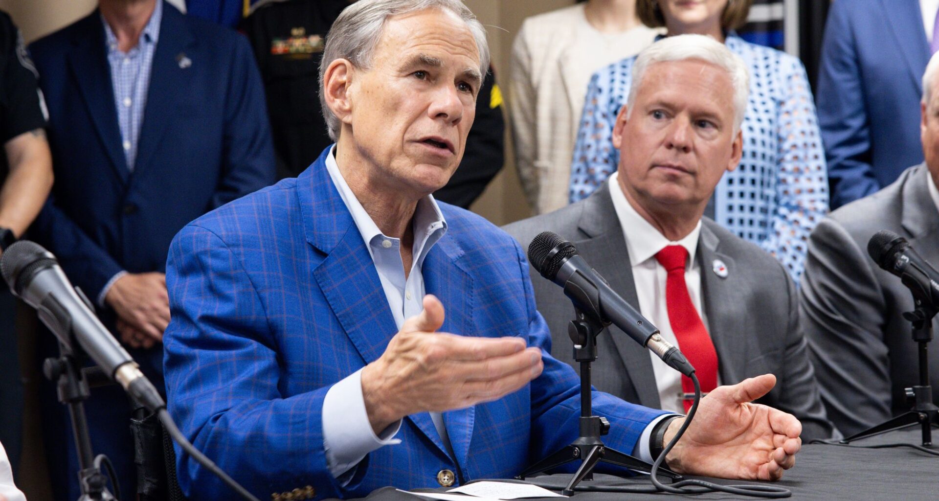Governor Greg Abbott speaks about new public safety initiatives that aim to safeguard Texas communities at the Arlington Police Officers Association in Arlington, TX, Thursday, May 28, 2026. Arlington Police Officers Association President Jesse Minton listens next to Abbott.