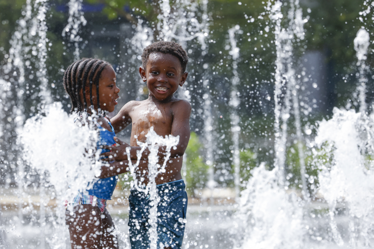 Cydney Hess, 4, and her cousin Bryson Richardson, 4, enjoy their time splashing around Nancy Best Fountain on Thursday, June 15, 2023, at Klyde Warren Park in Dallas.