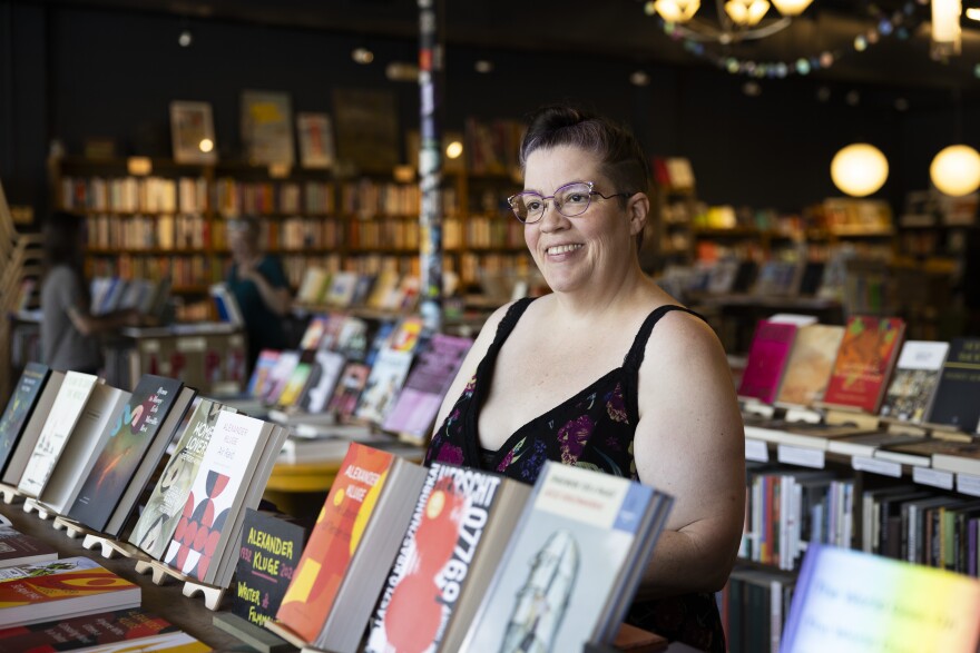 A woman poses for a photo inside of a bookstore.