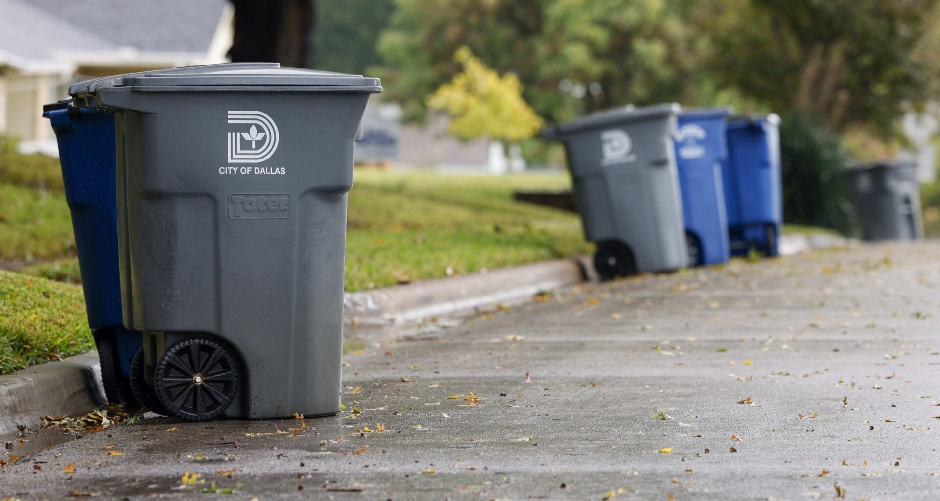 Recycling and garbage cans sit along a street in East Dallas in October 2022.