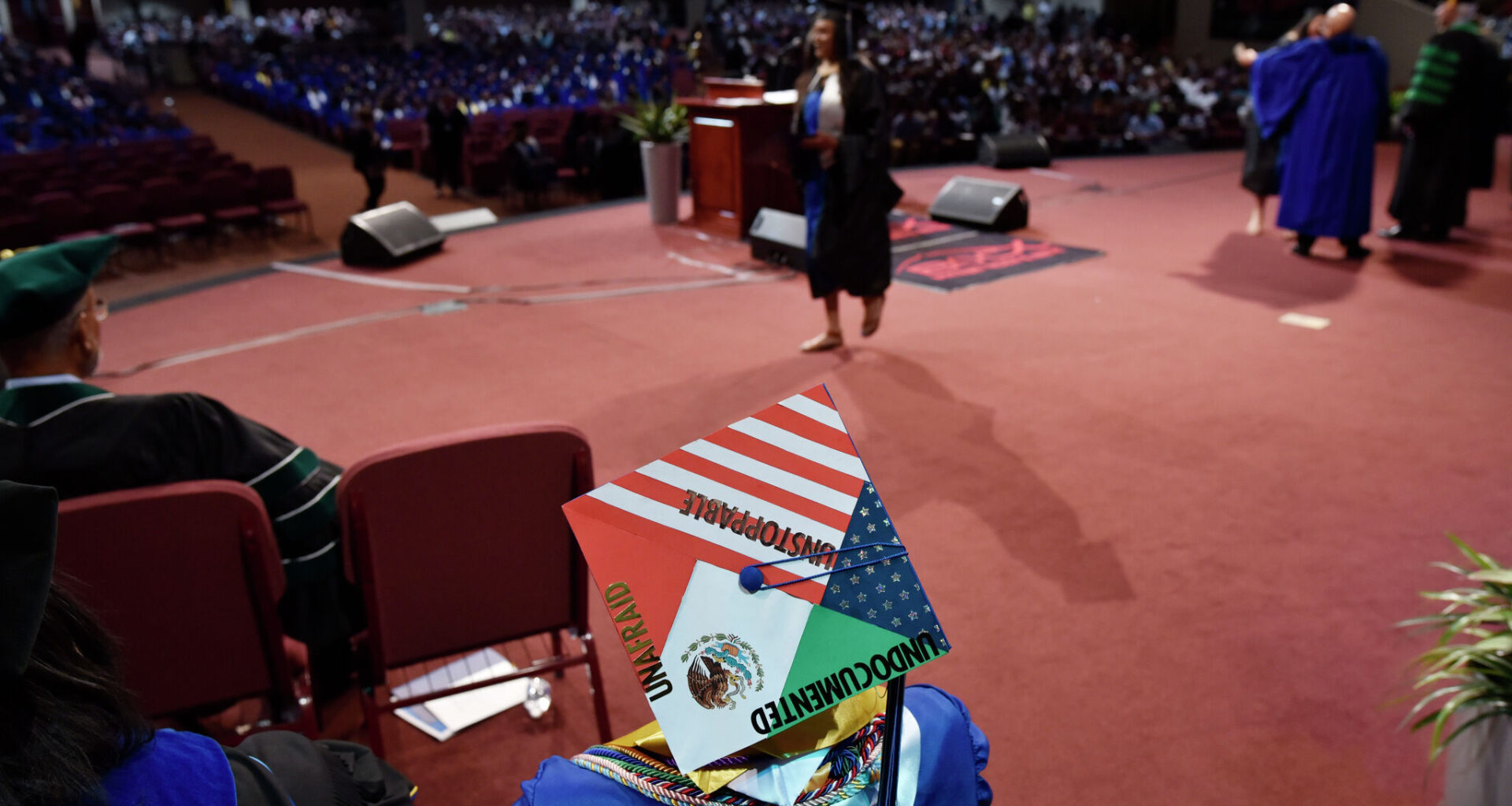 A graduate wears a decorated graduation cap as diplomas are awarded by the University of North Texas at Dallas on May 17, 2019. His cap reads, "unafraid, undocumented, unstoppable." 