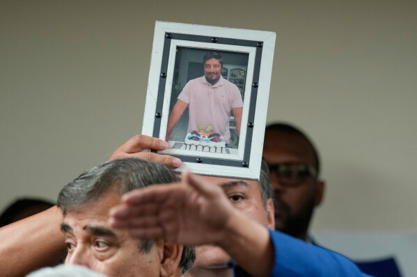 A photograph of Lorenzo Salgado Araujo is passed to the front during a news conference Wednesday, July 8, 2026, in Houston. (AP Photo/David J. Phillip)