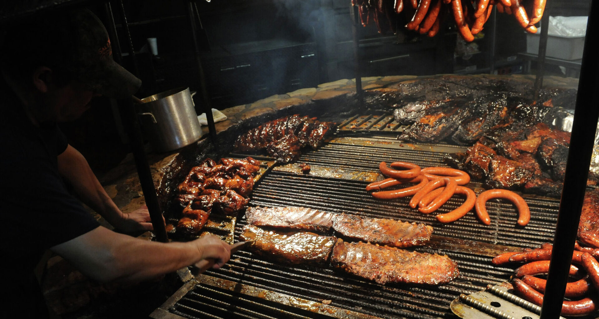 View of a chef cooking barbecued meats on an open-fire pit at the Salt Lick restaurant, Driftwood, Texas, December 14, 2015.