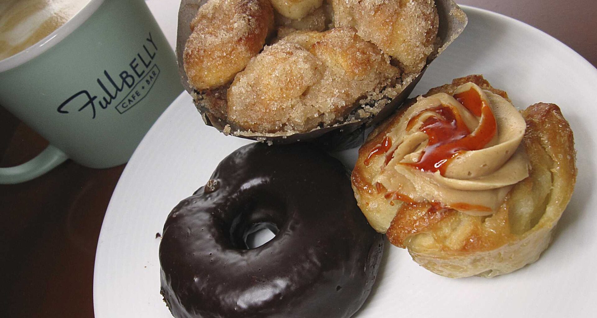 Baked goods made in-house include a chocolate doughnut, cinnamon-sugar monkey bread and a puff pastry with peanut butter cream filling and sriracha syrup at Full Belly Cafe and Bar.