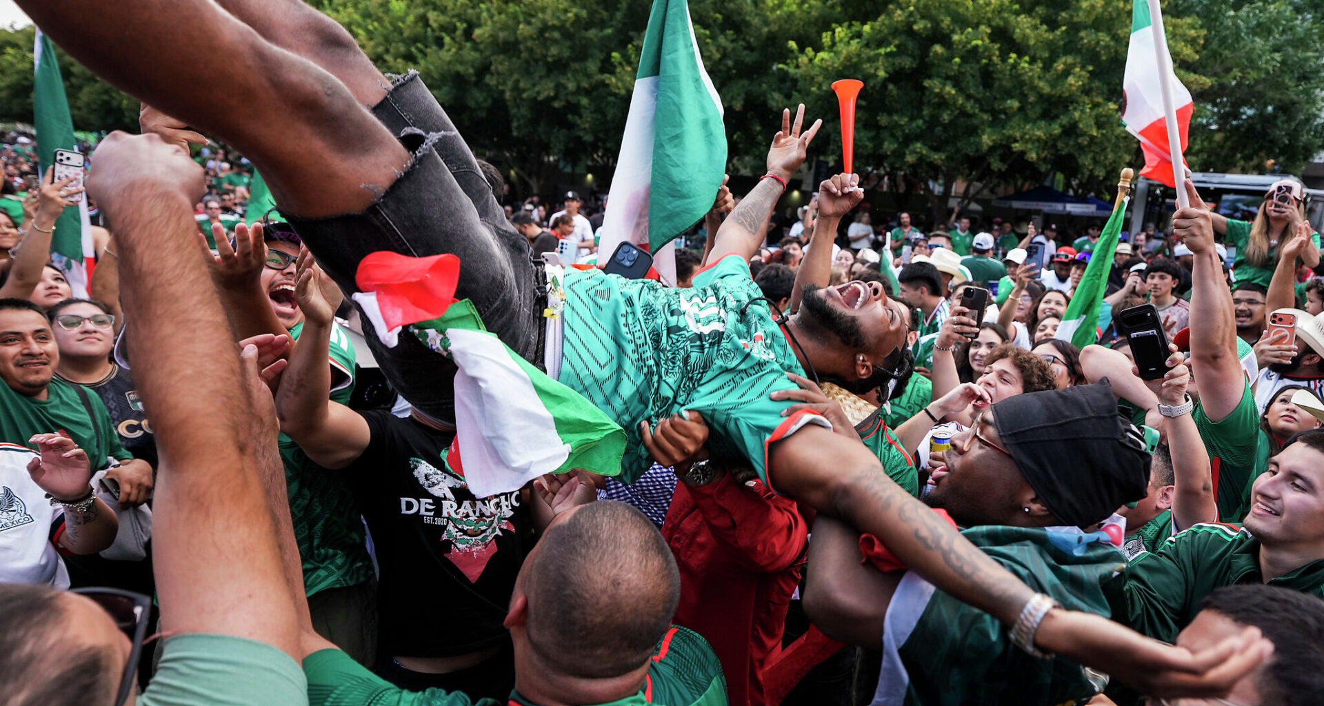 Mexico fans toss a fellow supporter in the air during a watch party at Klyde Warren Park during Mexico’s World Cup match against England on July 5. England won the match 3-2.