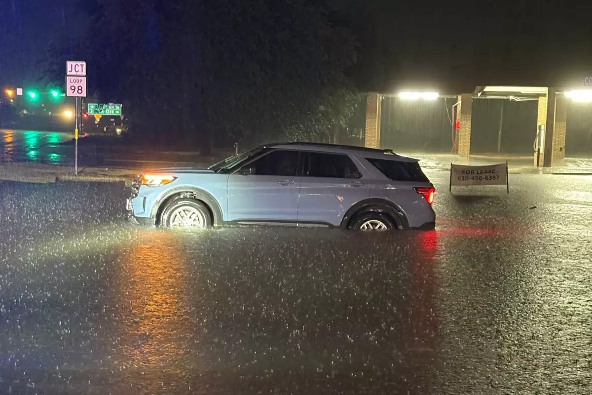 A vehicle sits stranded in high water in Kerrville early Tuesday, July 14, 2026, as heavy rain caused flooding across parts of the Texas Hill Country.
