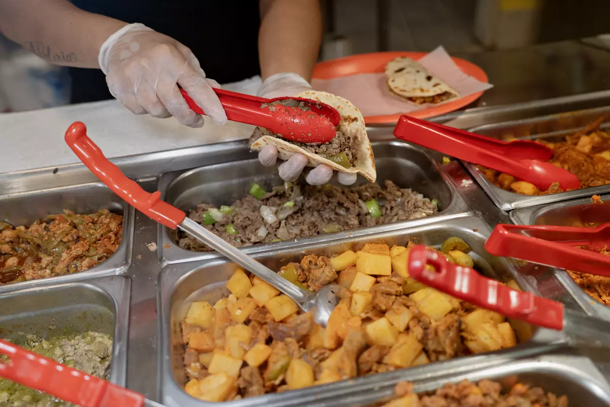 A worker at Monchy's prepares a taco order for a customer at the restaurant in Houston on July 11, 2026.