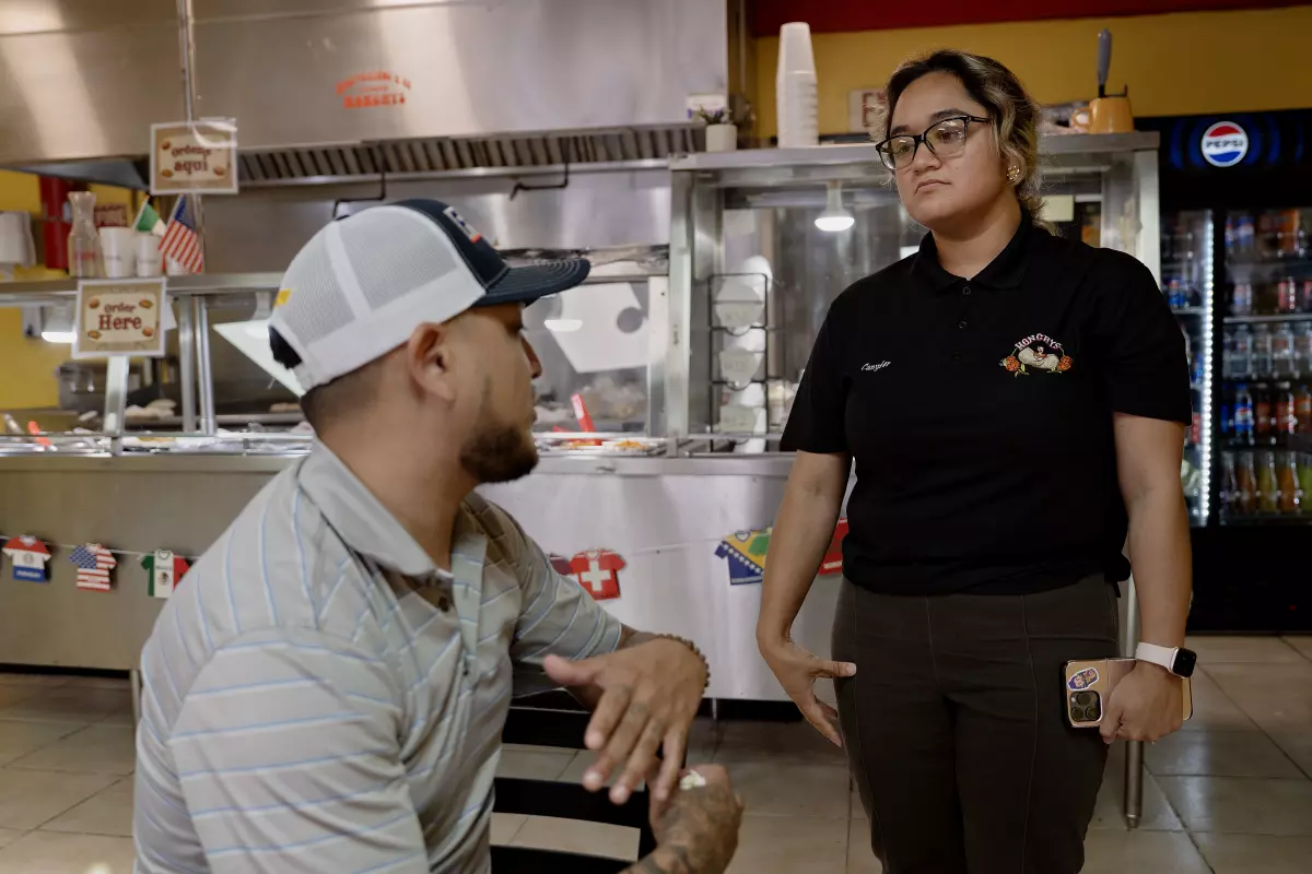 Lucinea Canyfer Vazquez talks with a customer at her family's restaurant.