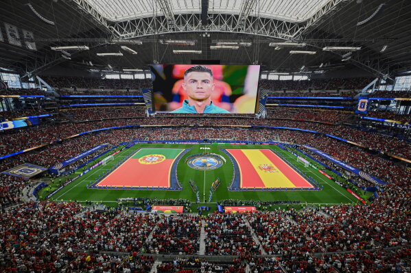 Flags for Portugal and Spain are displayed as Portugal's Cristiano Ronaldo is seen on a screen ahead of the World Cup round of 16 soccer match between Portugal and Spain in Arlington, Texas, near Dallas, Monday, July 6, 2026. (AP Photo/Jessica Tobias)