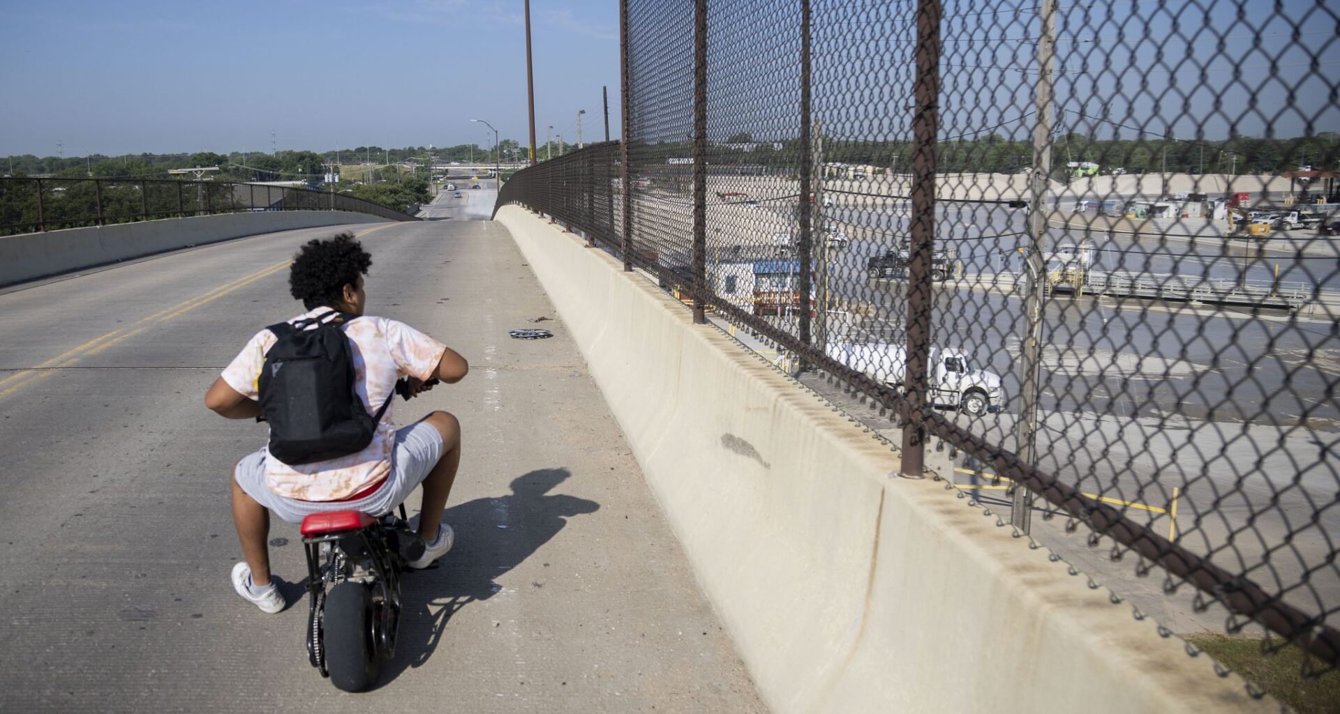 A Joppa resident on a motorbike looks toward the Austin Bridge & Road South Dallas Plant while riding over the Linfield Road bridge in Dallas on Wednesday, May 31, 2023.