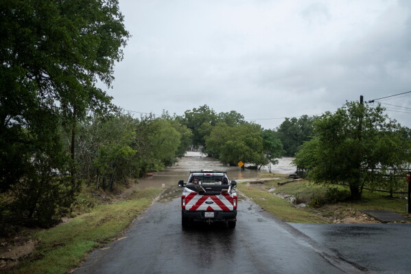 A first responder vehicle is parked as flooding moves along the Guadalupe River on Thursday, July 16, 2026, in Comfort, Texas. (AP Photo/Joel Angel Juarez)