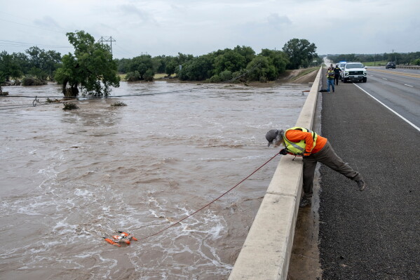 A U.S. Geological Survey hydrologic technician surveys water levels along the Pedernales River using an acoustic doppler profiler on Thursday, July 16, 2026, in Fredericksburg, Texas. (AP Photo/Joel Angel Juarez)