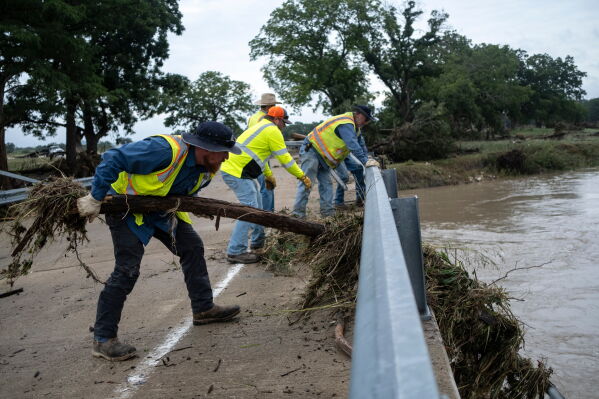 Crews clean up flood debris along the Guadalupe River on Friday, July 17, 2026, in Comfort, Texas. (AP Photo/Joel Angel Juarez)