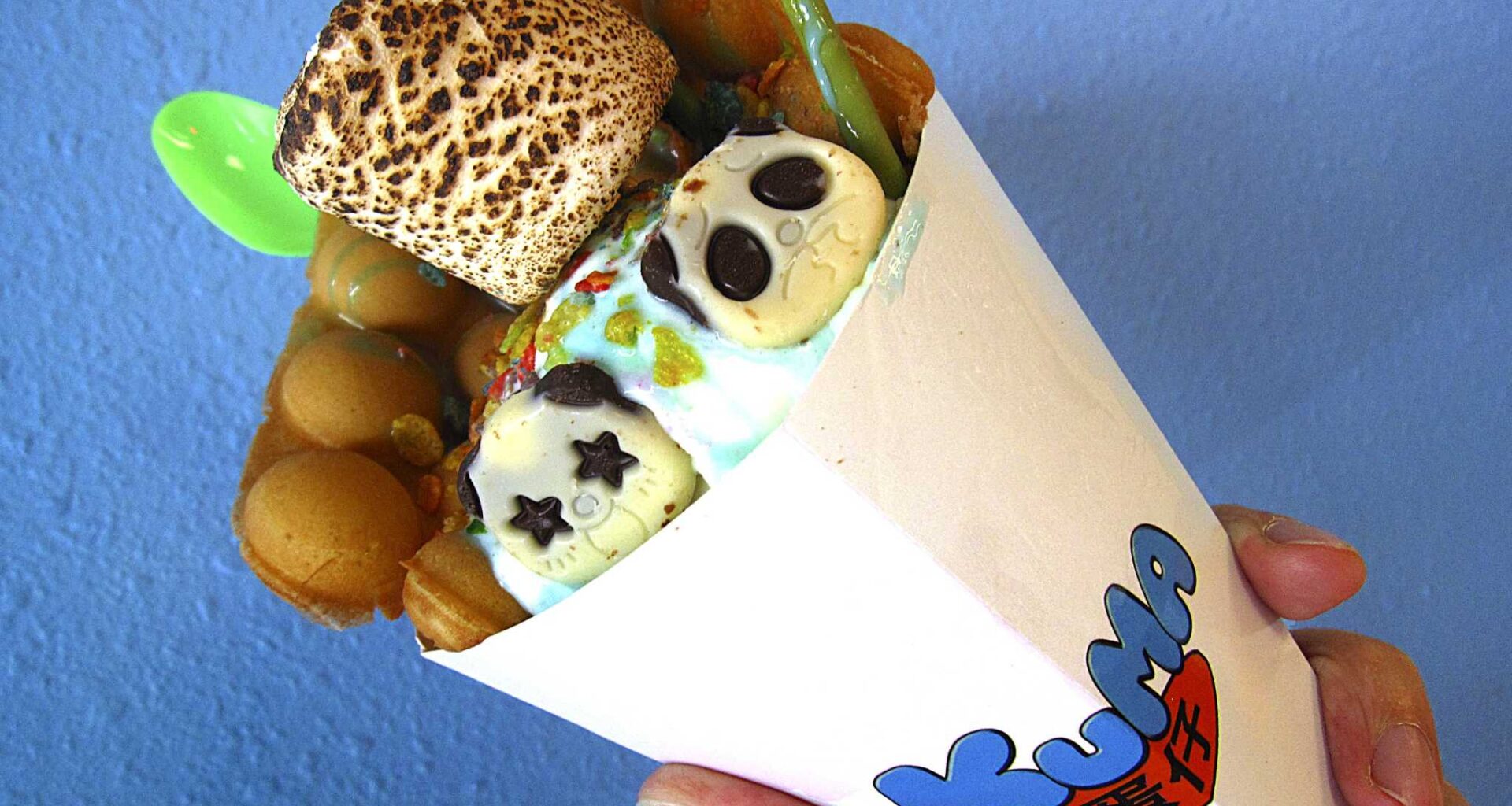 Hong Kong-style bubble waffle ice cream cone with unicorn ice cream, Fruity Pebbles, a toasted marshmallow and more from Kuma.