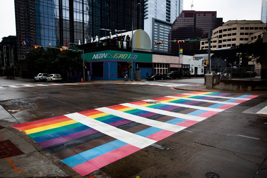 A crosswalk at 4th and Colorado streets with the colors of the Pride flag.