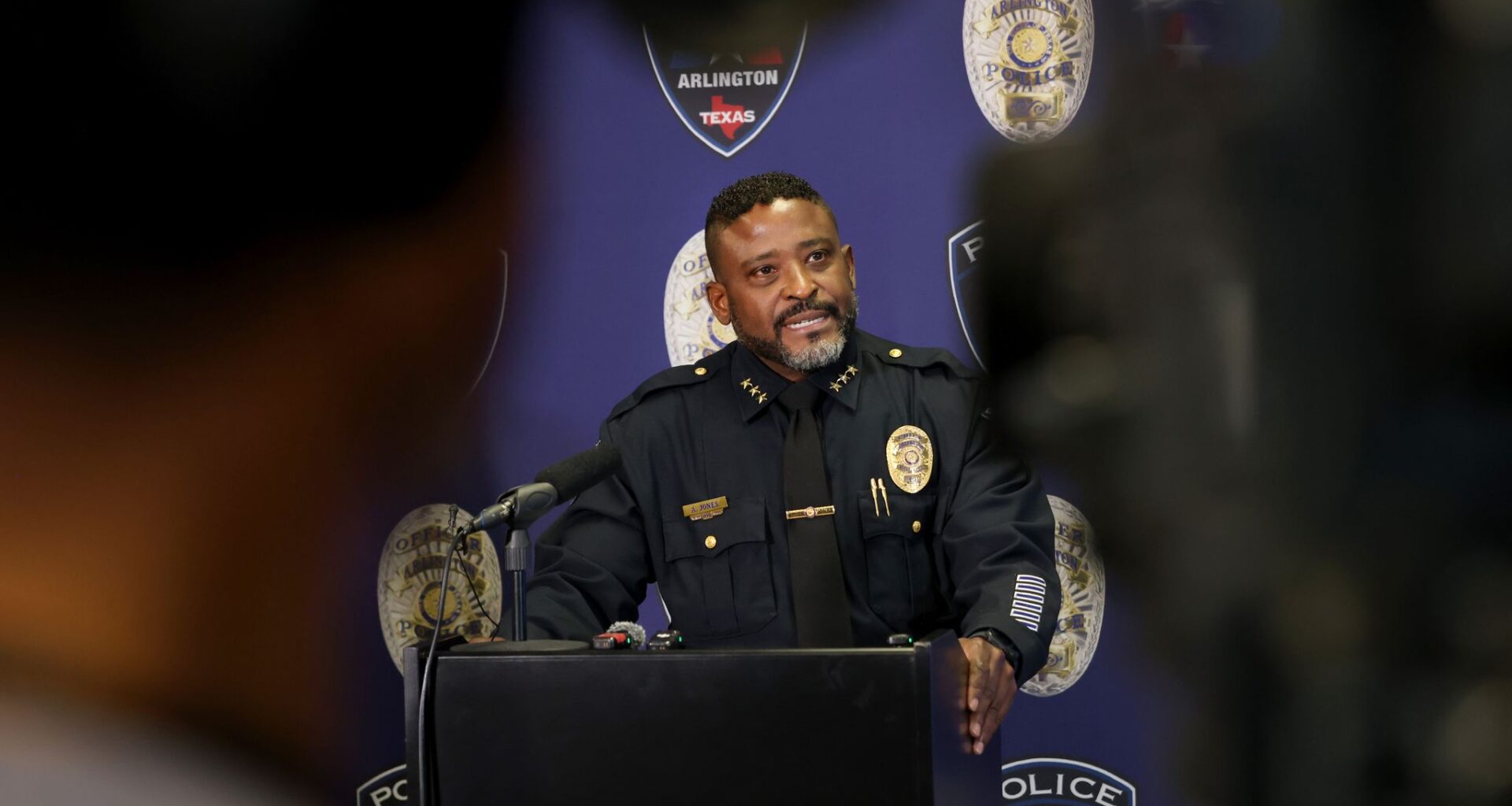 Arlington Chief of Police Al Jones is framed by a videographer as he addresses media members. The Arlington Police Department and FBI Dallas Field Office held a press conference to announce an arrest made in a cold case within the city from January of 2012. The press conference was held at APD headquarters, 620 W. Division Street in Arlington on July 22, 2026.