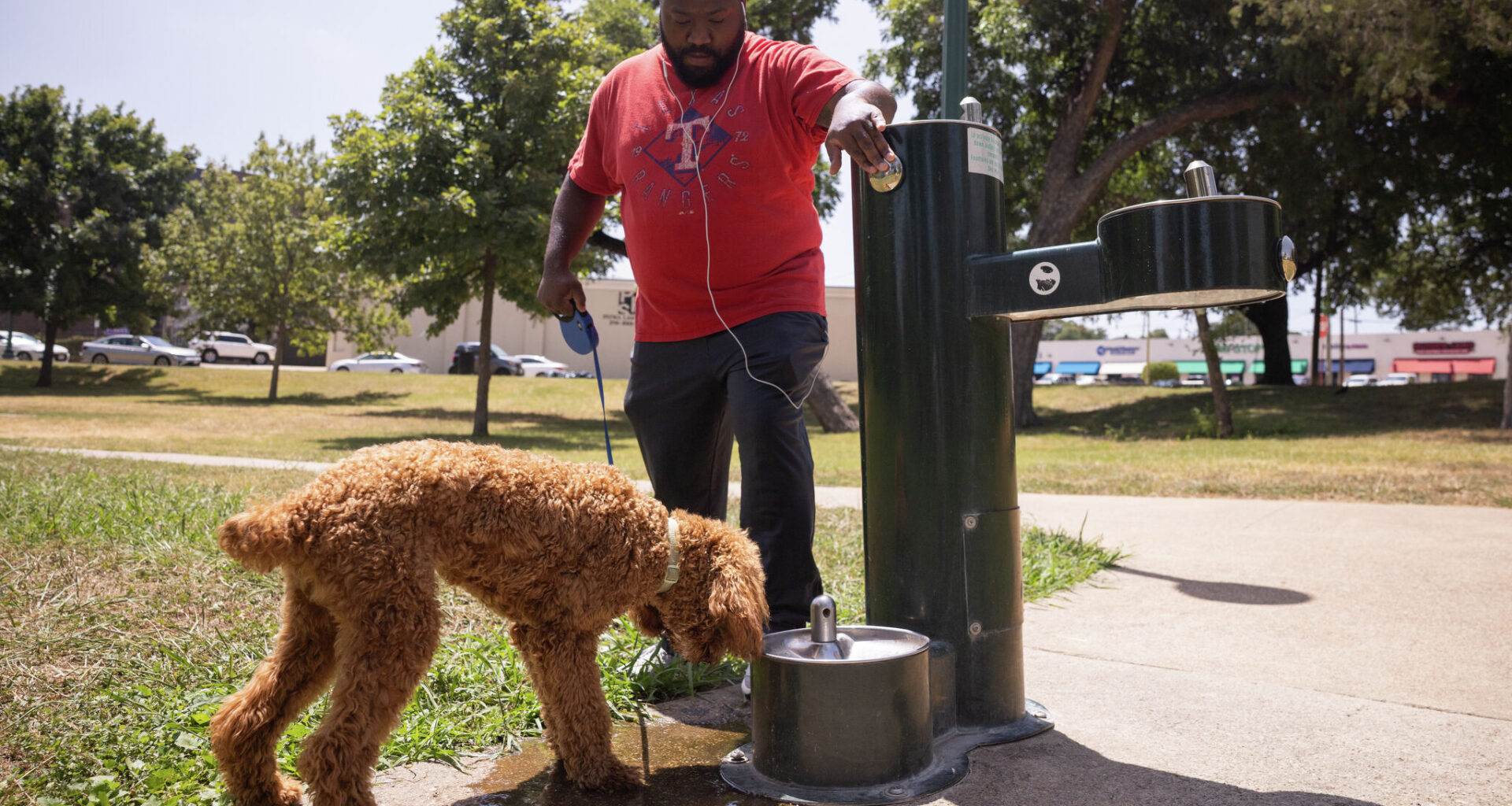 Jordan Butler and his dog Jax take a water break while walking at Lake Cliff Park in Dallas, Tuesday, July 21, 2026. Tuesday’s high is forecast by the weather service to be 105 degrees, with a heat index, or “feels like” temperature, of 112.