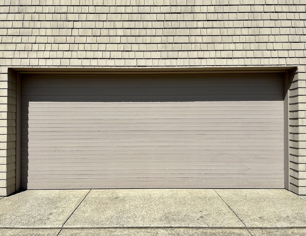 a white fire hydrant sitting in front of a garage door