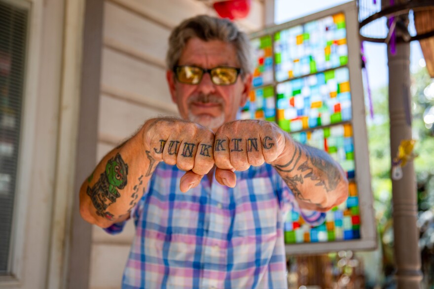 A man holds up his fists where the words junk and king are tattooed.