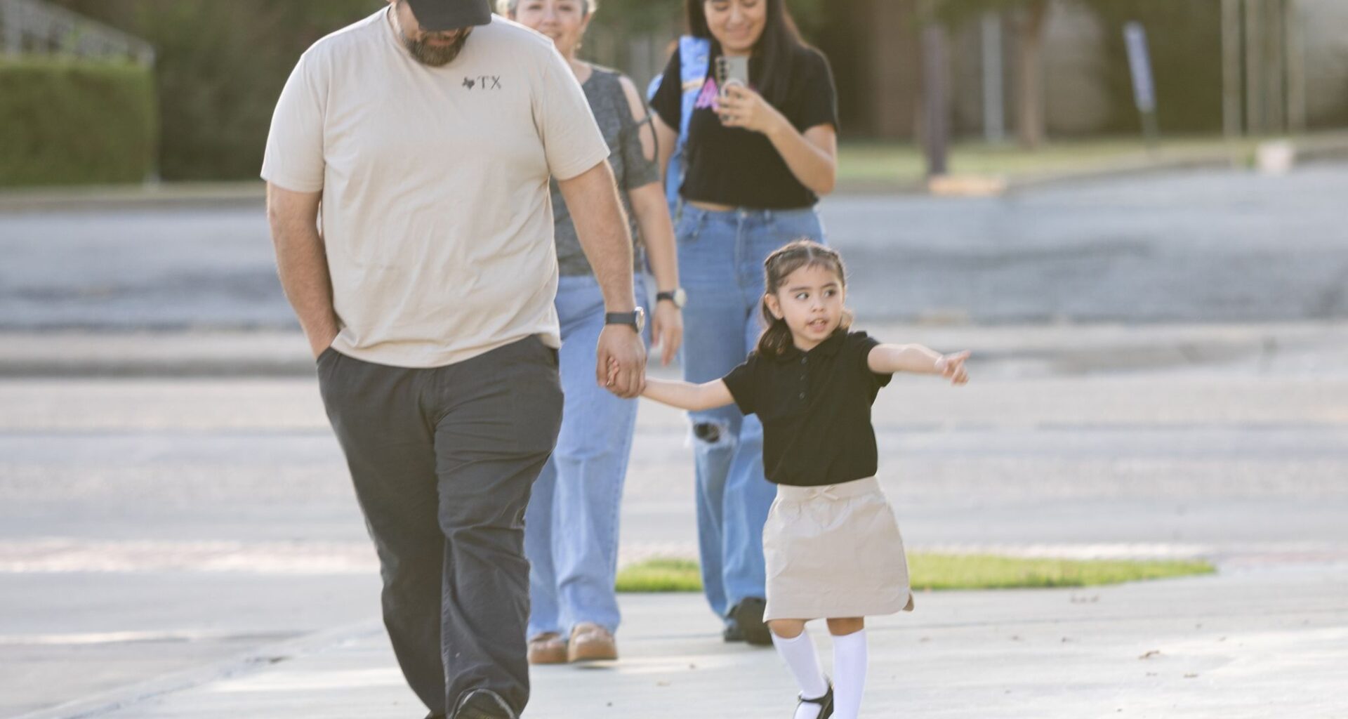 Pre-K student Amandra Perez, 3, points to her school while walking with dad Armando Perez before the first day of school at John Quincy Adams Elementary in Dallas on Tuesday, July 28, 2026. 