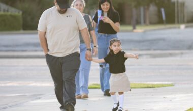 Pre-K student Amandra Perez, 3, points to her school while walking with dad Armando Perez before the first day of school at John Quincy Adams Elementary in Dallas on Tuesday, July 28, 2026. 