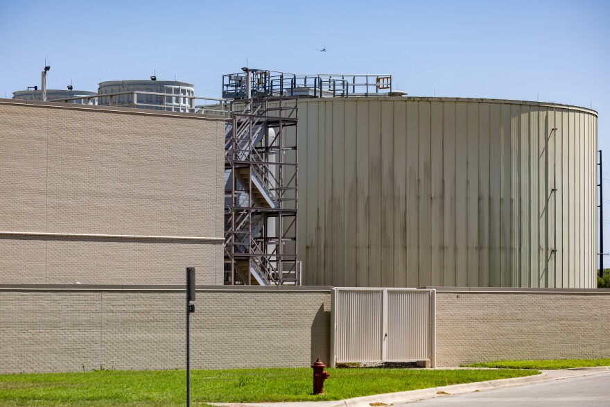 A building with a large water tank beside is is shown from the outside.