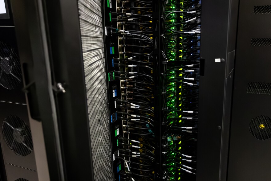 The interior of a computer server with lights and wires is shown.