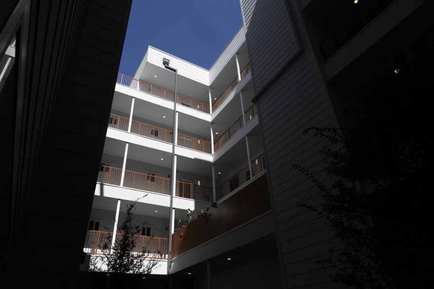 A building is seen from a low angle with darkness on either side of the frame.