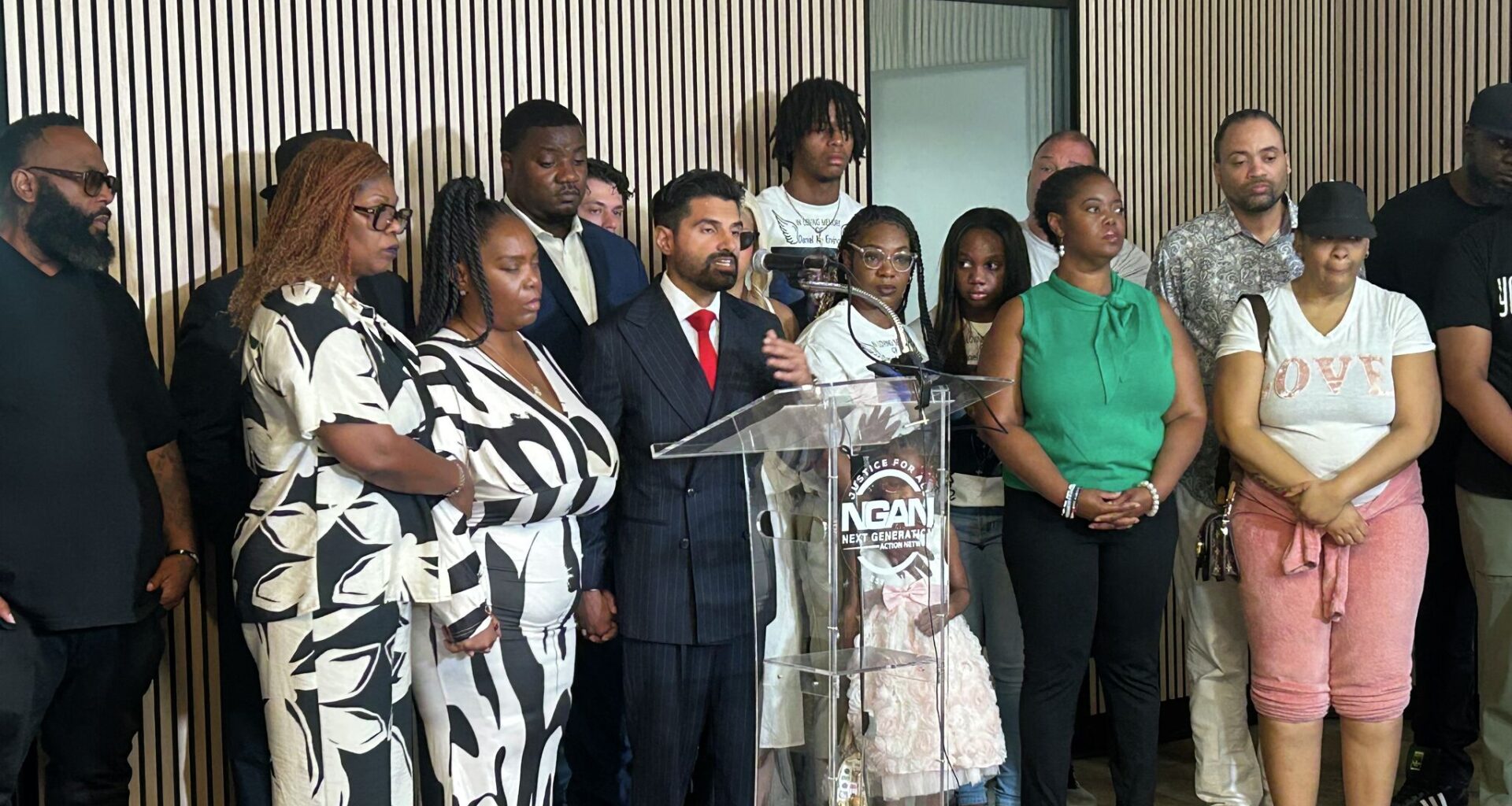 Sean Daredia, who represents Daniel Erving's family, speaks next to Erving's mother and aunt at a news conference on July 13, 2026. 