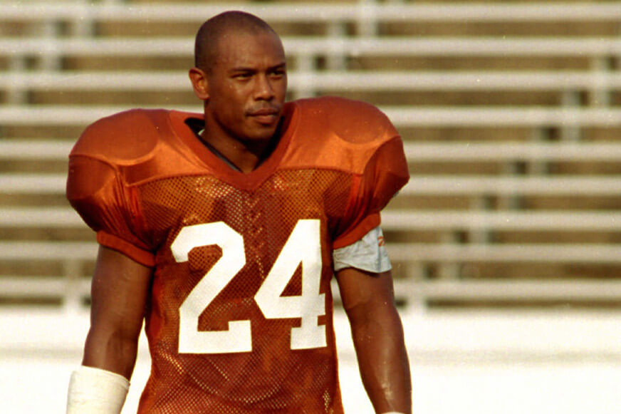 Ron Weaver stands with his helmet off wearing a Texas practice jersey