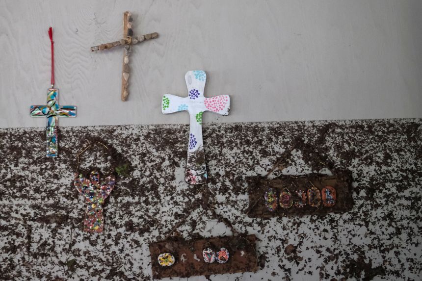 Crosses hang from a wall with flood marks, following flooding on the Guadalupe River, at Camp Mystic, in Hunt, Texas, on July 7, 2025.