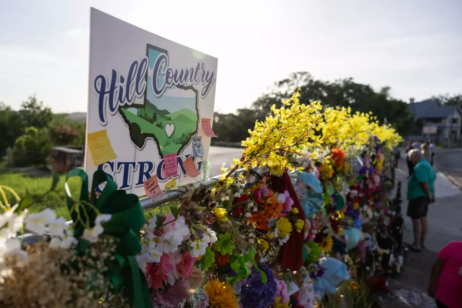 A Hill Country Strong sign is pictured among flowers, photos, notes, and toys for victims of the July Fourth flooding at the memorial wall on Thursday, July 17, 2025, in Kerrville, Texas.