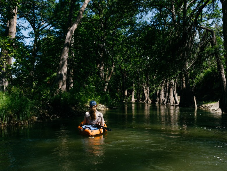 Texas Tribune reporter Emily Foxhall takes notes on a kayak on the Guadalupe River in Center Point, Texas on June 13, 2026.