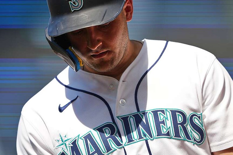 Seattle Mariners' Dominic Canzone walks back to the dugout after grounding out during the eighth inning of a baseball game against the Cincinnati Reds, Wednesday, July 22, 2026, in Seattle. (AP Photo/Lindsey Wasson)