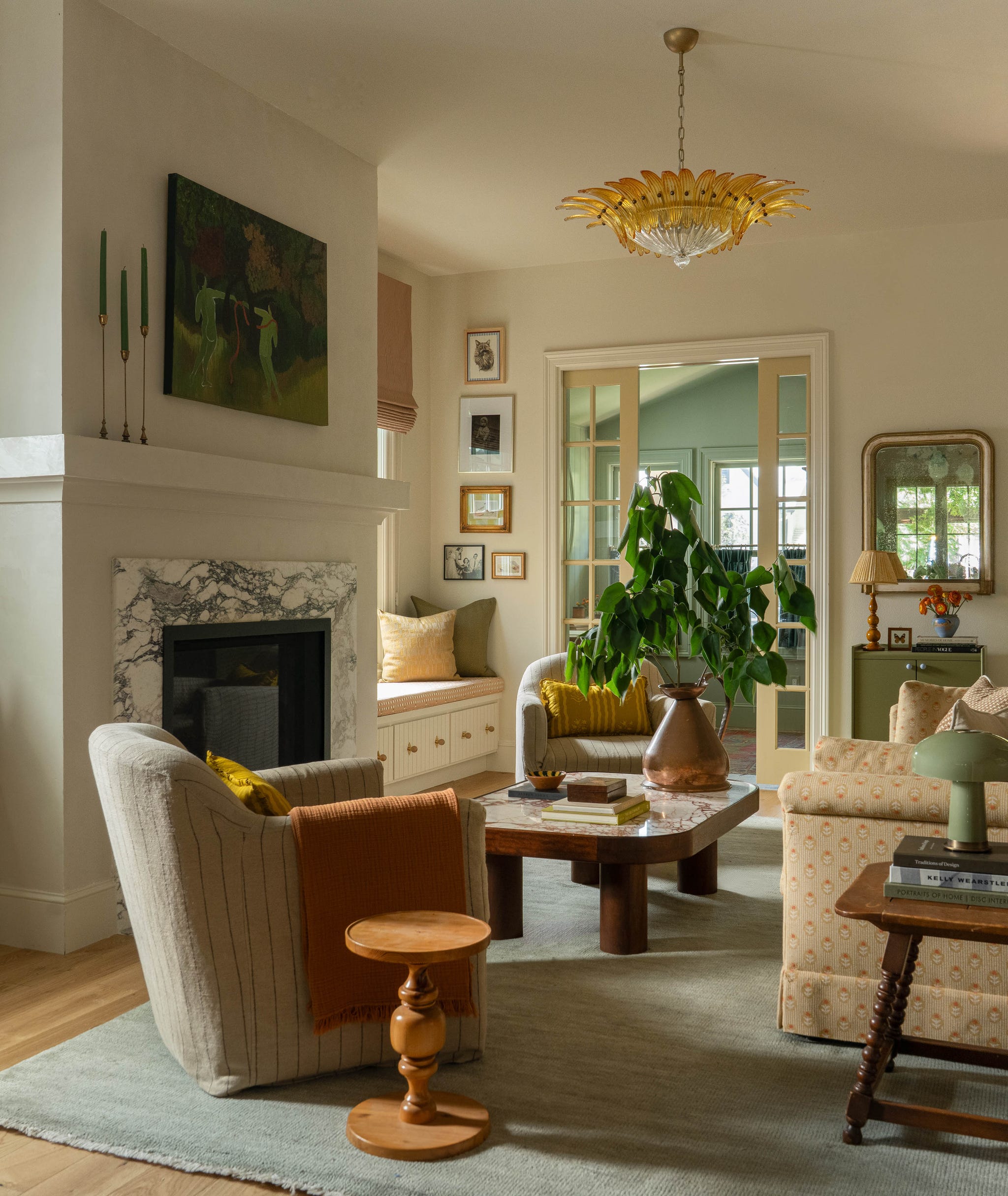 Cozy living room featuring a fireplace, modern decor, plants, and an artistic chandelier.