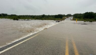 flooded roadway with high river to the left of road