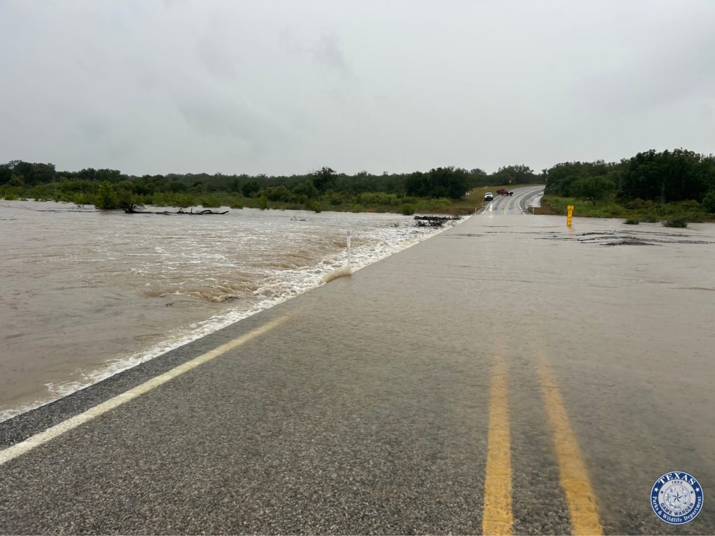 flooded roadway with high river to the left of road