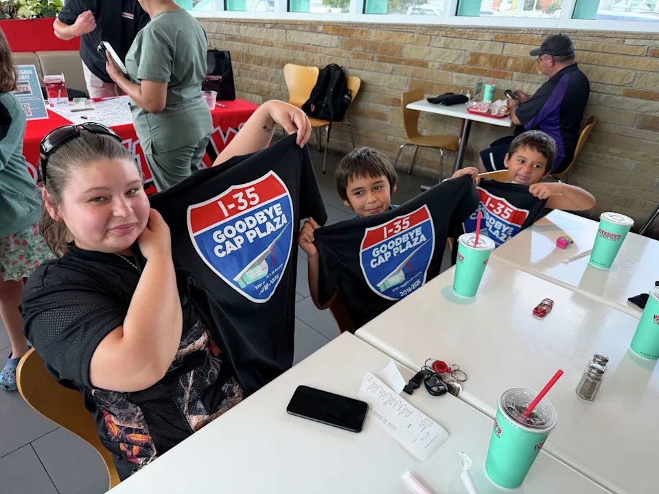 P. Terry's guests hold up complimentary T-shirts with a sign saying goodbye to the chain's Capital Plaza location off Interstate 35 in Austin on Friday, June 26. (Devon Messinger/Courtesy of P. Terry's)