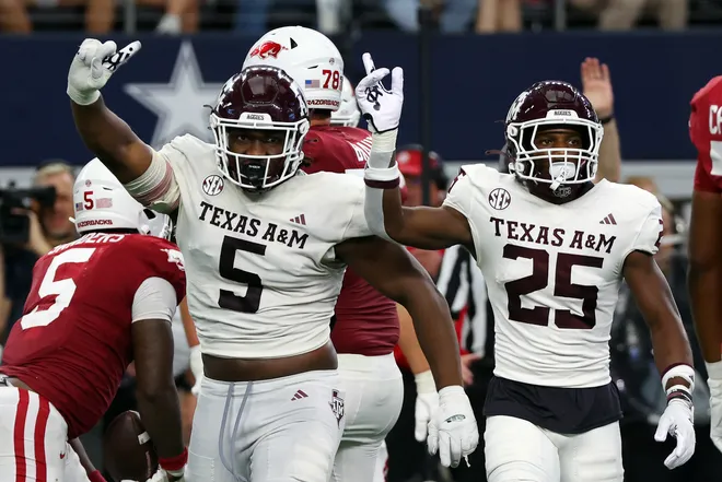 ARLINGTON, TEXAS - SEPTEMBER 30: Defensive lineman Shemar Turner #5 and defensive back Dalton Brooks #25 of the Texas A & M Aggies gesture after stopping a run by running back Raheim Sanders #5 of the Arkansas Razorbacks in the fourth quarter of the Southwest Classic at AT & T Stadium on September 30, 2023 in Arlington, Texas. (Photo by Richard Rodriguez/Getty Images)