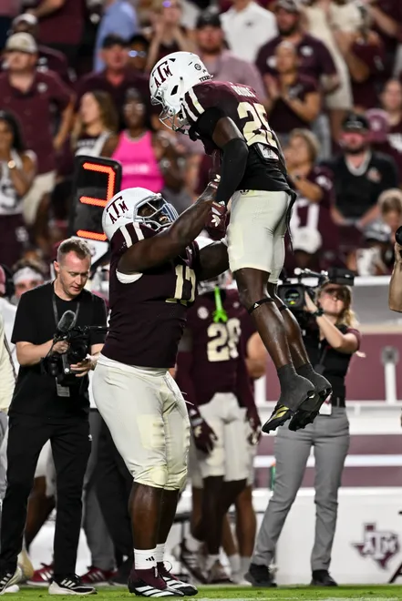 Oct 11, 2025; College Station, Texas, USA; Texas A & M Aggies defensive tackle Albert Regis (17) hoists safety Dalton Brooks (25) after he recovered a fumble in the third quarter against the Florida Gators at Kyle Field. Mandatory Credit: Maria Lysaker-Imagn Images